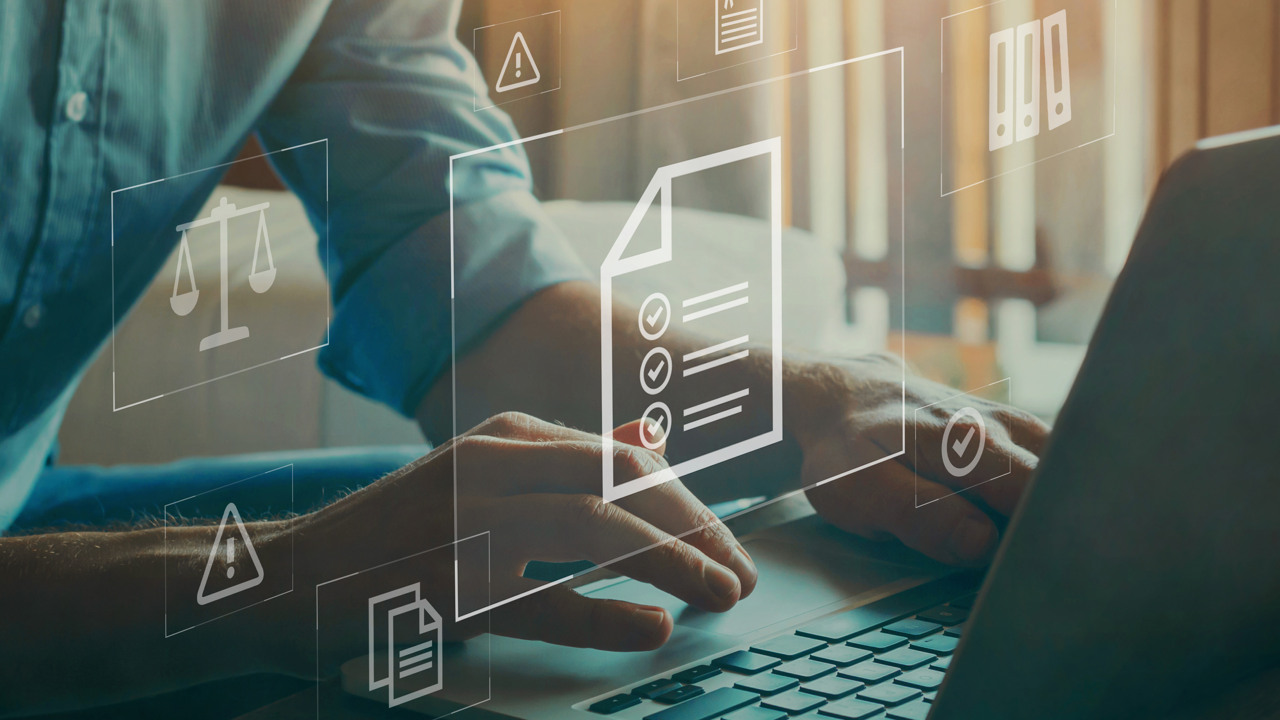 En man jobbar vid en dator med virtuell skärm som visar olika dokument.